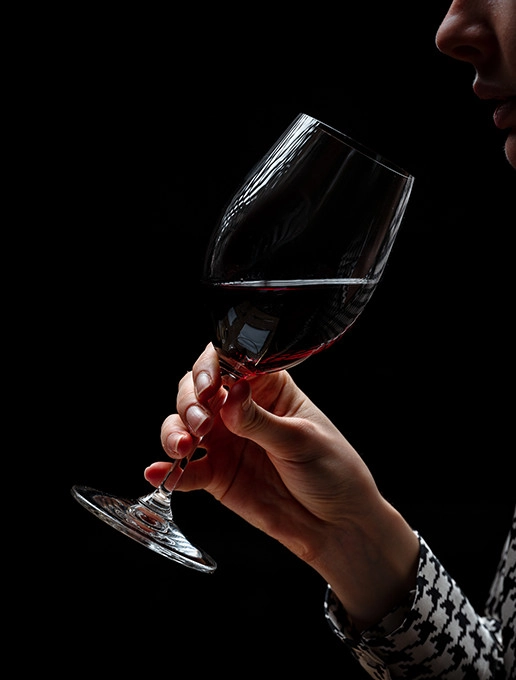 A young woman savouring a glass of wine in a cozy ambiance to celebrate Christmas at Dans le Noir ?