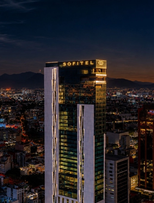 El Sofitel Mexico City Reforma se ilumina sobre el horizonte de la Ciudad de México al atardecer.