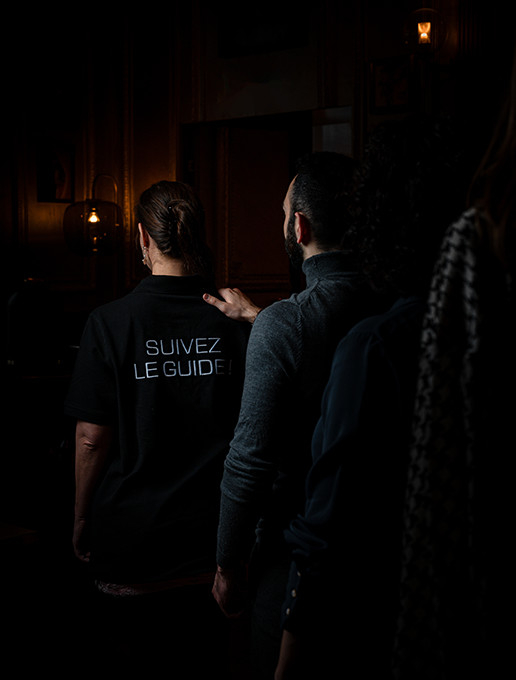 Guests walking in single file on their way to an immersive birthday party at the restaurant Dans le Noir ?